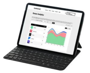 A tablet with a detachable keyboard displays a stream analytics dashboard, featuring a chart and app icons on the screen.